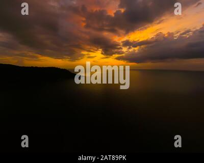 Blick auf den Sonnenuntergang über dem Meer, Phuket, Thialand. Sonnenuntergang über dem Meer. Ruhige idyllische Szene mit goldenem Sonnenuntergang über dem Meer mit r Stockfoto