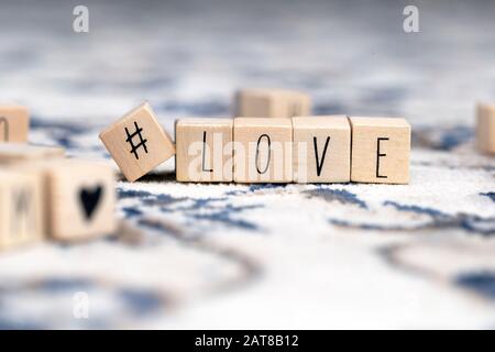 Holzwürfel mit Hashtag und dem Wort Liebe, soziale Medien und Valentinen-Konzept Hintergrund Stockfoto