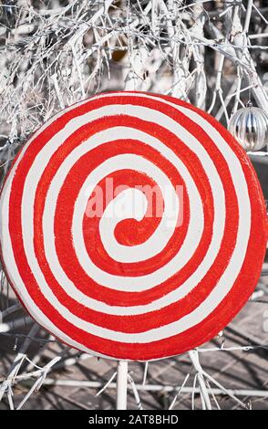 Nahaufnahme eines runden rot-weißen Wirrs auf einem Stock, der als Teil einer weihnachtsdekoration einen Lollypop vor einem schwarz-weißen Hintergrund darstellt Stockfoto