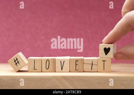 Holzwürfel mit einem Hashtag und den Worten gefällt es, Hintergrund des Social-Media-Konzepts Stockfoto