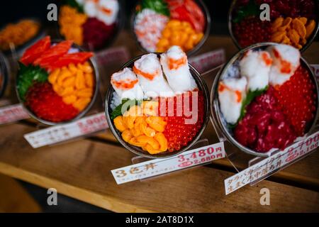 Große Nähe zu Plastikschüsseln japanischer Speisen, die außerhalb eines Restaurants ausgestellt werden. Stockfoto