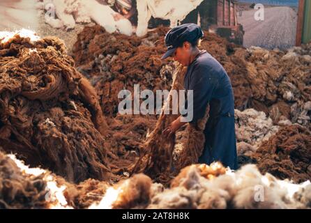 Arequipa, Peru - 20. Juli 2010: Herstellung Von Alpaka-Wolle. Arbeiter, Die Braune Fasern in einer Alpaca Wool Manufacturing Facility sortieren. Stockfoto