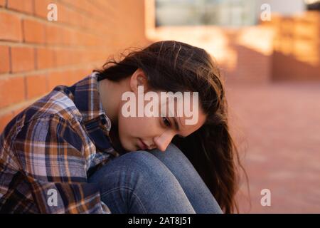 Teenager-Mädchen auf dem Schulgelände sitzen Stockfoto