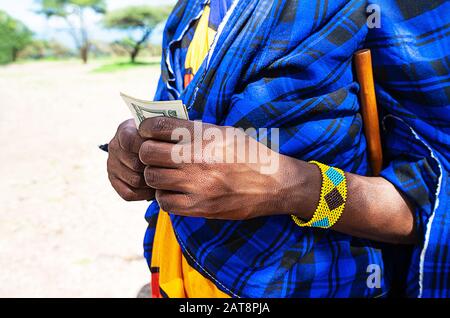 Afrikanischer Mann rechnet Geld und zählt Dollar. Nahaufnahme. Stockfoto