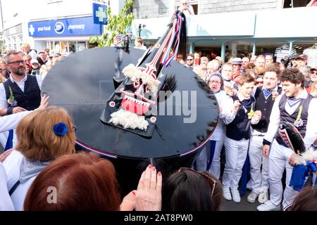 Menschenmassen folgen der Obby Oss-Prozession mit blauen Bändern, Padstow, Cornwall, Großbritannien Stockfoto