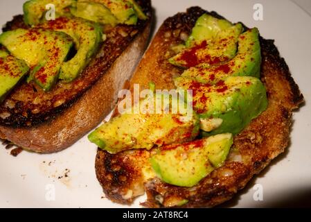 Avocado garniert mit Paprika auf gebuttertem Toast aus nächster Nähe Stockfoto