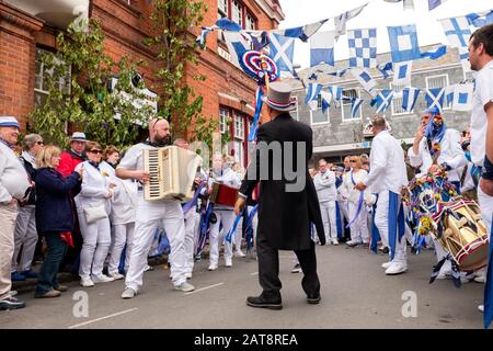 Der Meister der Feierlichkeiten in der Hut führt die Massen nach dem blauen Band Obby Oss Prozession, Padstow, Cornwall, Großbritannien Stockfoto