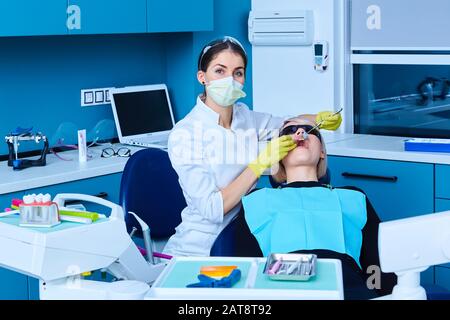 Schöne Frau Patienten mit zahnärztlichen Behandlung beim Zahnarzt. Frau, die ihr Zahnarzt Stockfoto