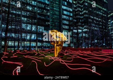 "Fortuna"-Skulptur von Helaine Blumenfeld umgeben von Angus Muir Design Installation "Squiggle". 2020 Winter Lights Festival in Canary Wharf. Stockfoto