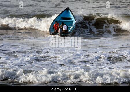 Männer begeben sich in einer Piroge, Grand Riviere, Trinidad & Tobago in die Brandung Stockfoto