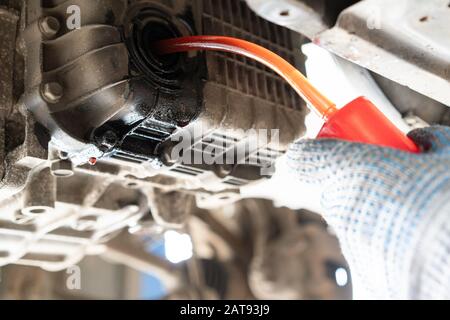 Wechseln des Motoröls in einem Pkw. Fahrzeug auf einer Hebebühne in einem Auto Service Stockfoto