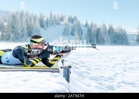 Biathlet schießt in Bauchlage auf Trainingsgelände Stockfoto