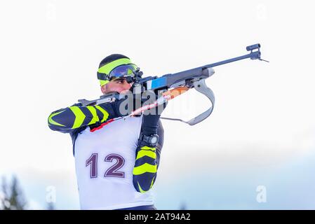 Biathlet schießt auf Stehposition. Athlet mit moderner Ausstattung. Nahaufnahme Stockfoto