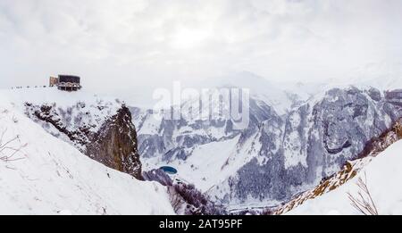 Panorama des Kreuzpasses, Georgia, Winter. Das Denkmal der Völkerfreundschaft und der georgischen Militärstraße. Winter, Schnee, Berge, Kälte, Touristen Stockfoto