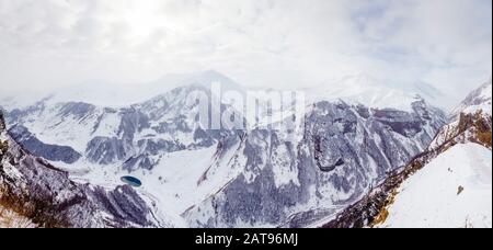 Georgia, Cross-Pass, Bergpanorama an einem Wintertag. Sonne, Wolken, Nebel, Gipfel und Schluchten im Schnee. Stockfoto