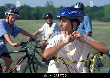 Austin, Texas: Der 13-jährige Junge zieht vor dem Mountainbiken richtig Fahrradhelme an. ©Bob Daemmrich Stockfoto