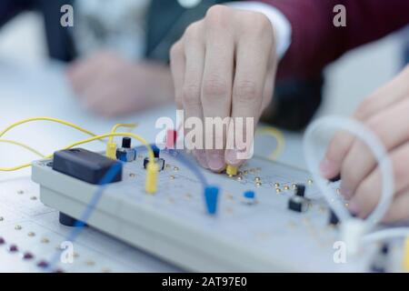 Ingenieurstudenten, die im Labor arbeiten. Die Teilnehmer passen die Komponenten einer Elektrik im Labor an. Stockfoto