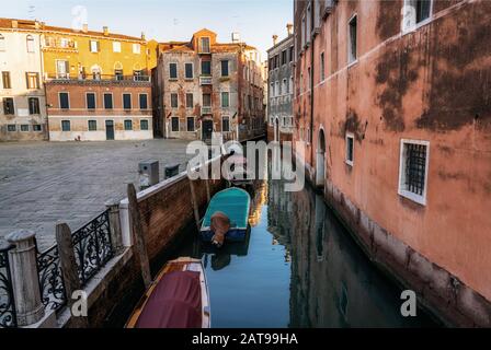 Traditionelles Stadtbild Venedigs mit schmalem Kanal, vermoorten Booten und alten bunten Gebäuden auf dem Platz Campo Sant'Angelo, Italien Stockfoto