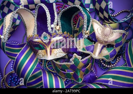 Festliche mardi Gras-, venetian- oder Karnevalsmaske auf violettem Hintergrund. Draufsicht Stockfoto