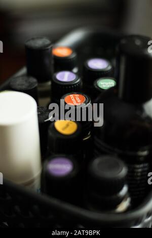Glasflasche mit Weihrauchdeckel aus ätherischem Öl in einem schwarzen Behälter mit anderen Flaschen mit verschwommenem Hintergrund Stockfoto