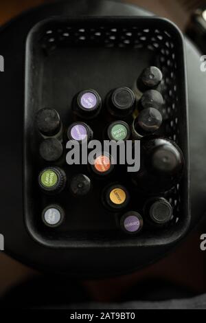 Deckel von Glasflaschen mit ätherischen Ölen in einem schwarzen Behälter nach unten füllen Stockfoto