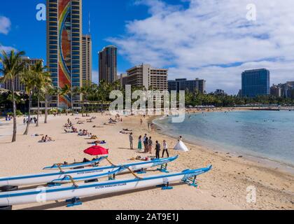 Waikiki, HI - 19. Januar 2020: Traditionelle Kanus vor dem Hilton Rainbow Tower am Waikiki Strand auf Hawaii Stockfoto