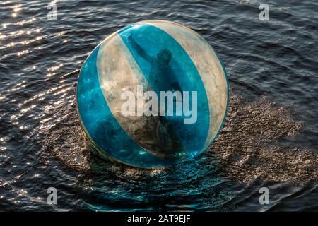 Wasserball Mit Jungen Mann, der an einem Sumer-Abend auf der Moldau, Prag, Tschechien steht Stockfoto