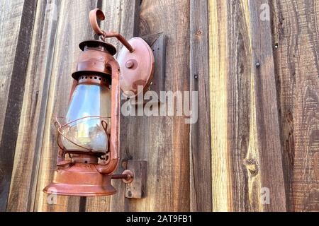 Eine verrostete alte Kabinenlaterne auf Holzscheune Stockfoto