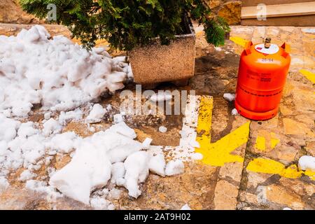 Bocairent, Spanien - 22. Januar 2020: Orangefarbene Butangasflasche, um Energie für die Beheizung von Häusern im Winter zu liefern und die Kälte des SNO zu bekämpfen Stockfoto