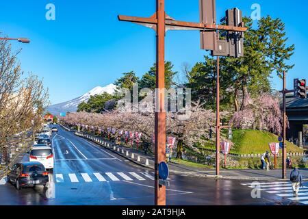 Blick auf die Straße in der Stadt Hirosaki im Frühling sonniger Tag. Kirschblütenmatsuri-Festival, Besucher genießen die Schönheit voller Blüte rosa Sakura-Bäume Blumen. Stockfoto