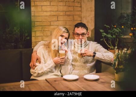 Wunderschönes Paar, das Kaffee zu einem bestimmten Zeitpunkt hat und zusammen Spaß hat. Ein Paar junge Leute, die in der modernen Cafeteria Kaffee trinken. Ein Paar, Das Im Café Ruht Stockfoto