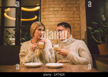 Happy Couple Meeting And Drinking Coffee. Liebe und romantisches Datum im Café-Restaurant in der Innenstadt. Junges glückliches Paar verliebt sich in das Café. Junge Paare datieren in Stockfoto