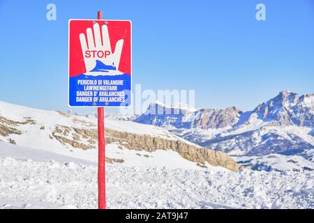 Lawinenwarnschild mit Lawinengefahr in italienischer, deutscher, französischer und englischer Sprache, hoch oben in den Bergen der Dolden, Italien. Stockfoto