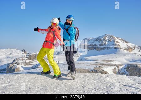 Zwei Skifahrer posieren auf Sass Pordoi (Pordoi-Gipfel), mit Piz Boe Berggipfel im Hintergrund, während einer Pause von der Sellaronda-Skitour, auf A. Stockfoto