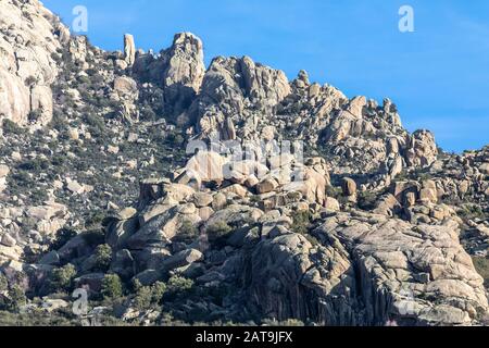 'La Pedriza' Panoramablick ein erstaunliches Felslabyrinth in einem Pinienwald unter einem blauen Himmel und Wolken. Felsige Gegend im Guadarrama Nationalpark Stockfoto