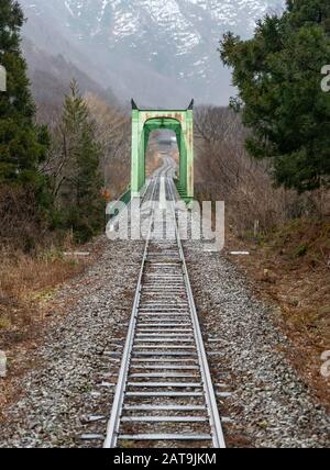 Eine Brücke und Gleise, die von einem Zug der JR East Yonesaka Line in der Präfektur Yamagata, Japan, aus gesehen werden. Stockfoto