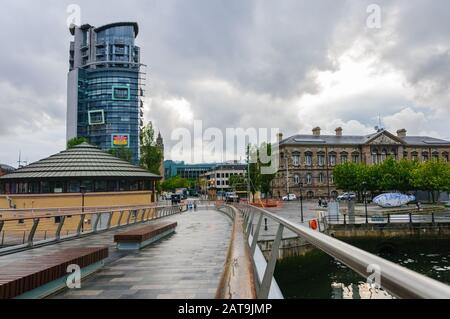 Belfast/Northern Ireland-May 18, 2019: Fußgängerbrücke überquert den Lagan River im Stadtzentrum von Belfast an einem bewölkten, regnerischen Tag. Stockfoto