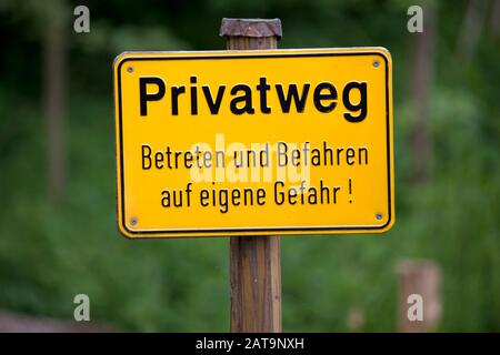 Private Bodenzeichenwarnung in deutscher Sprache Textübersetzung "Private Ground, Eintrag auf eigenes Risiko" Stockfoto