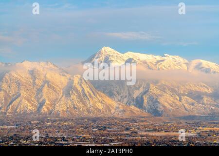 Atemberaubende Aussicht auf den Berg Timpanogos mit Winterschnee und goldenem Glanz bei Sonnenuntergang Stockfoto