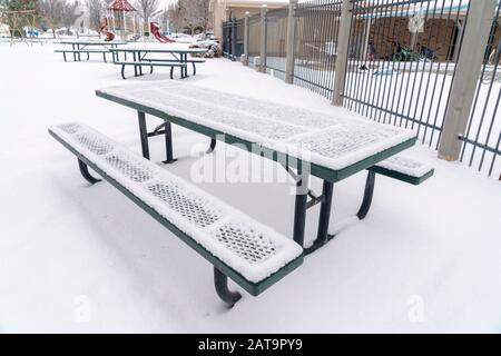 Park Picknick-Tisch und Bänke gegen schneebedeckten Boden an einem kalten Wintertag Stockfoto