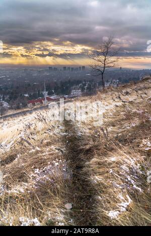 Goldene untergehende Sonne und dunkler wolkig Himmel über der Innenstadt von Salt Lake City im Winter Stockfoto