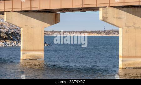 Panorama-Rahmen Fokus auf eine Balkenbrücke durch Abutments über blauen See gegen bewölkten Himmel unterstützt Stockfoto