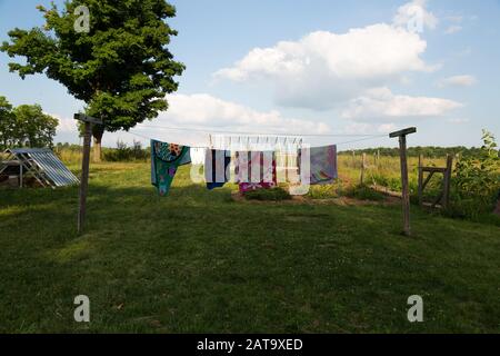 Strandtücher hängen an einer Wäscheleine, um sie in einem DeKalb County Hof unter einem schönen Himmel in der Nähe von Spencerville, Indiana, USA, zu trocknen. Stockfoto