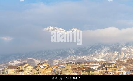 Foto Panorama Schneeberg teilweise von dicken Wolken bedeckt mit Häusern im Vordergrund Stockfoto