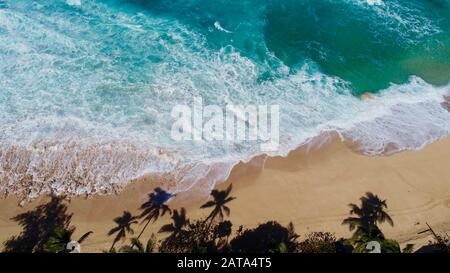 Luftaufnahme von hellblauem Wasser und Brandung mit Wellen, die in der Bonzai-Pipeline und im Sunset Beach Park an Nordufer, Haleiwa, Oahu, Hawaii, USA abstürzen. Stockfoto