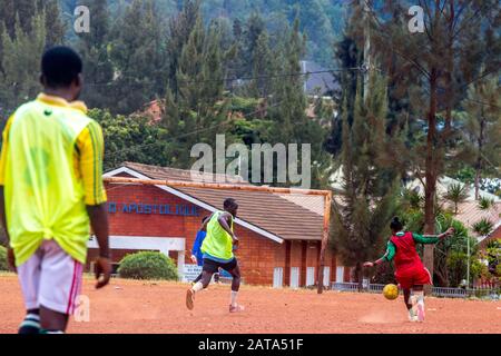 Mädchen, die auf einem Spielplatz gegenüber dem Centre Culturel Islamique Nyamirambo (Kwa kadhafi) in Kigali, Ruanda Fußball spielen. Stockfoto