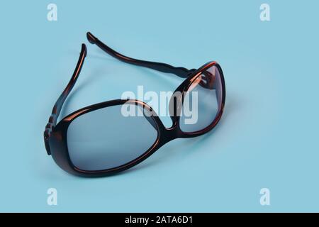 Schwarze Sonnenbrille für Frauen isoliert auf blauem Hintergrund Stockfoto