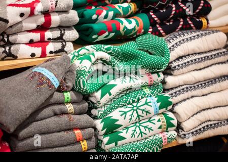 Pullover mit Weihnachtsornamenten im Laden.Stapel aus gefalteten Strickwaren Stockfoto