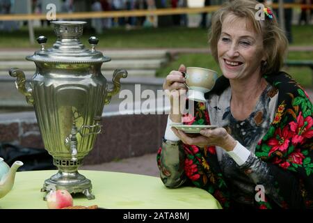 Weißrussland, die Stadt Gomil, 21. November 2015. Die Straßen der Stadt. Russische Frau trinkt Tee aus einem Samovar. Stockfoto