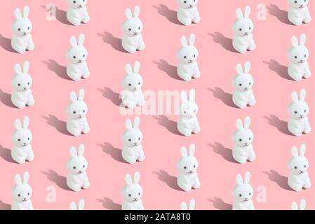 Easter Seamless Muster aus weißen Hasen auf pastellrosa Hintergrund minimales kreatives Konzept. Stockfoto